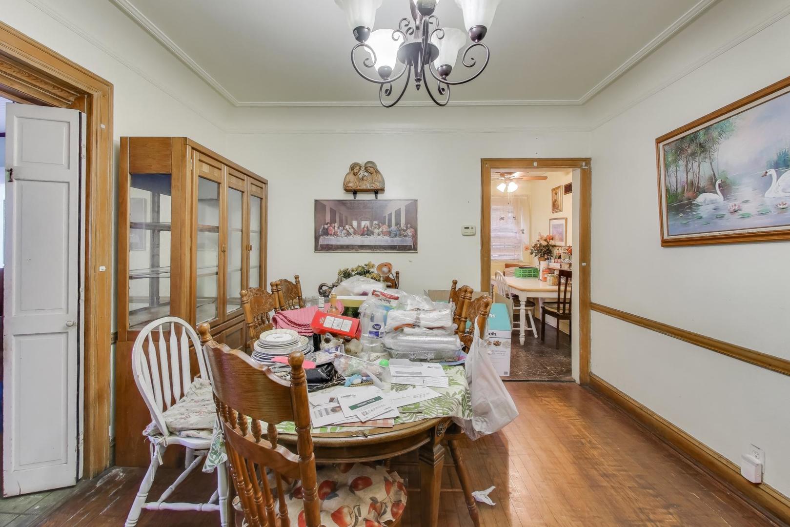 2859 North Mango Avenue Chicago, IL 60634 - Photo 11 of 24 a view of a dining room with furniture a chandelier and wooden floor