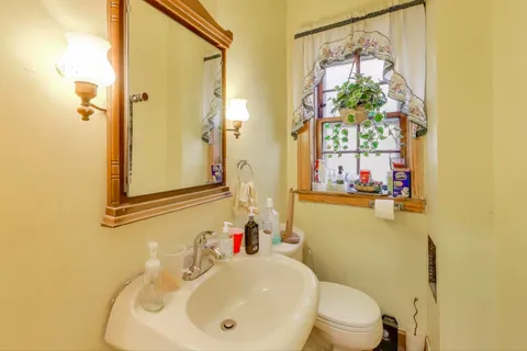 a bathroom with a granite countertop sink a toilet and shower