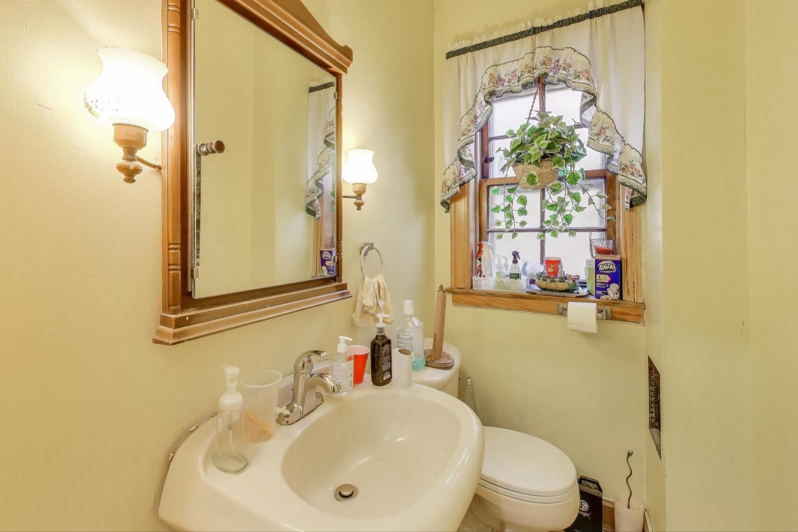 2859 North Mango Avenue Chicago, IL 60634 - Photo 17 of 24 a bathroom with a sink and mirror with toilet