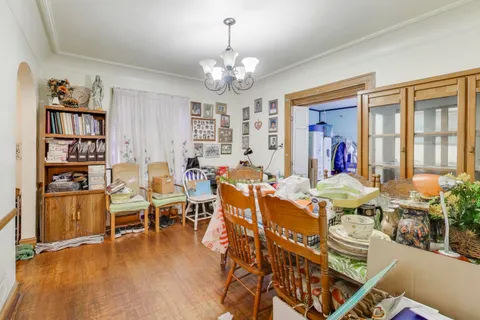 a view of a dining room with furniture a chandelier and wooden floor