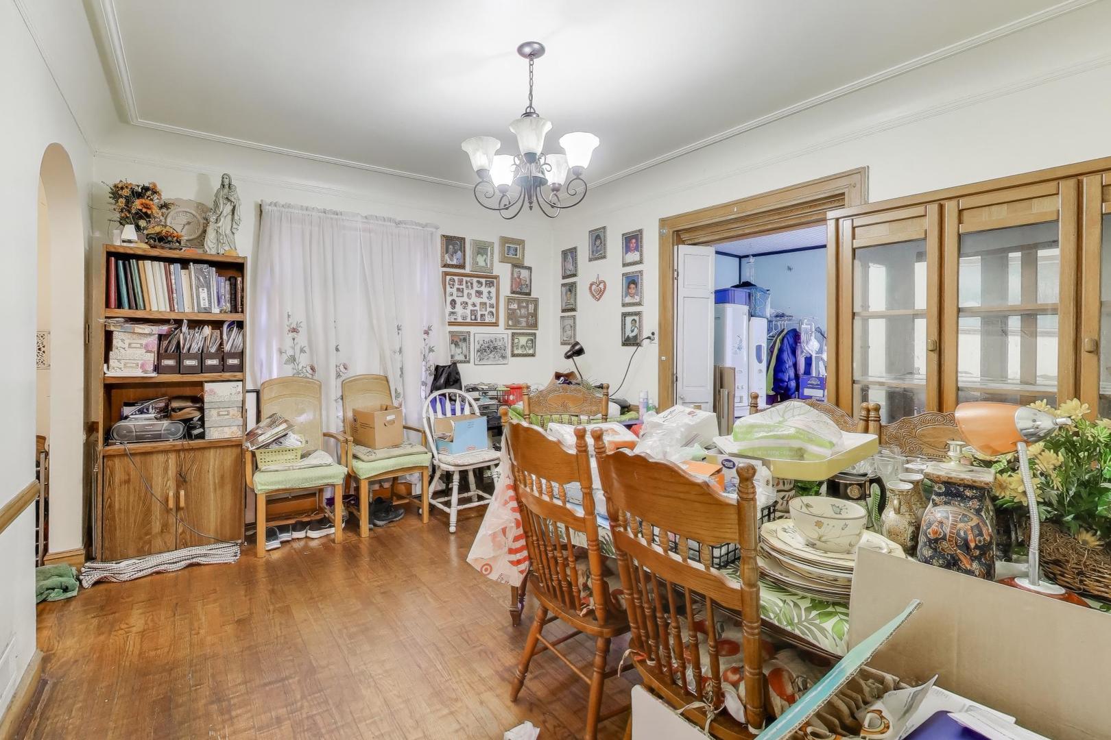 2859 North Mango Avenue Chicago, IL 60634 - Photo 10 of 24 a view of a dining room with furniture wooden floor and a chandelier