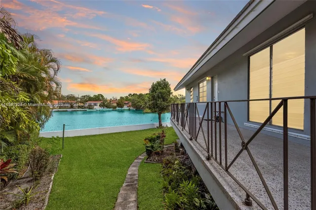 a room with pool table and large windows