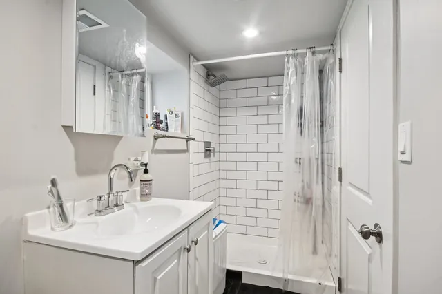 a bathroom with a sink mirror and shower