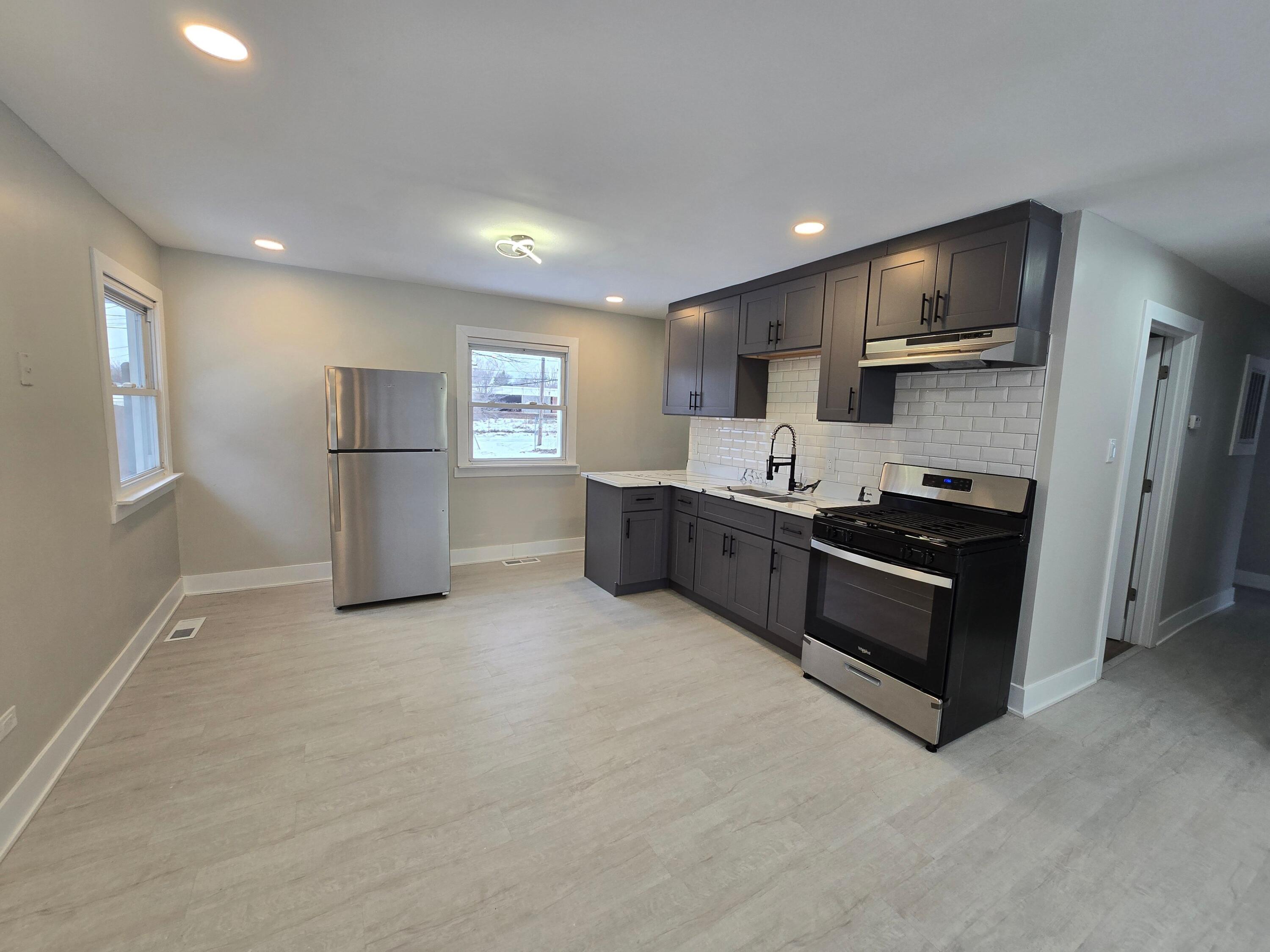 730 Clinton Street Gary, IN 46406 - Photo 5 of 17 a kitchen with stainless steel appliances granite countertop a refrigerator stove microwave and sink