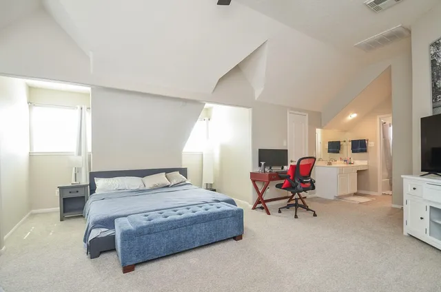 a bedroom with a bed a chair and glass windows