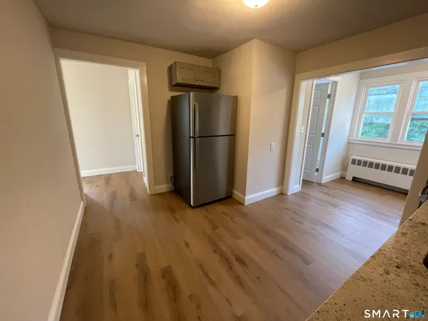 a view of a kitchen with wooden floor electronic appliances and windows