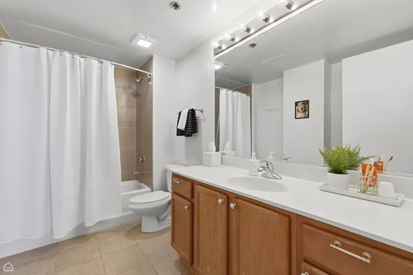a spacious bathroom with a double vanity sink toilet and a mirror
