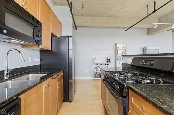 a kitchen with stainless steel appliances granite countertop a sink stove and refrigerator