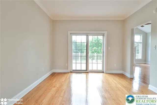 an empty room with wooden floor windows and a fireplace