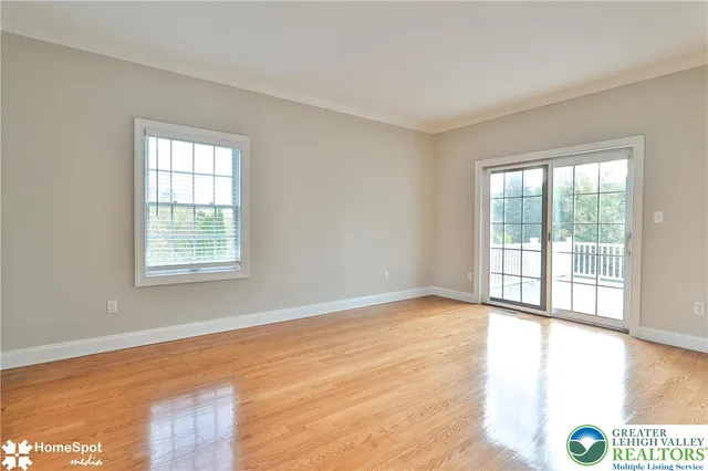 a view of a hallway with wooden floor and cabinet