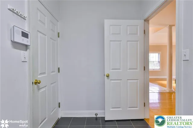 an empty room with chandelier fan and windows