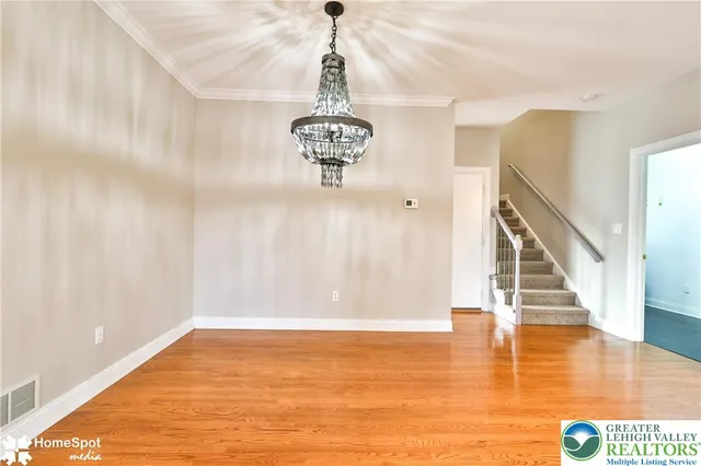 a view of a room with wooden floor and windows