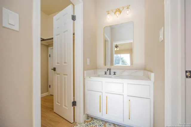 a en suite bathroom with a granite countertop sink and a mirror