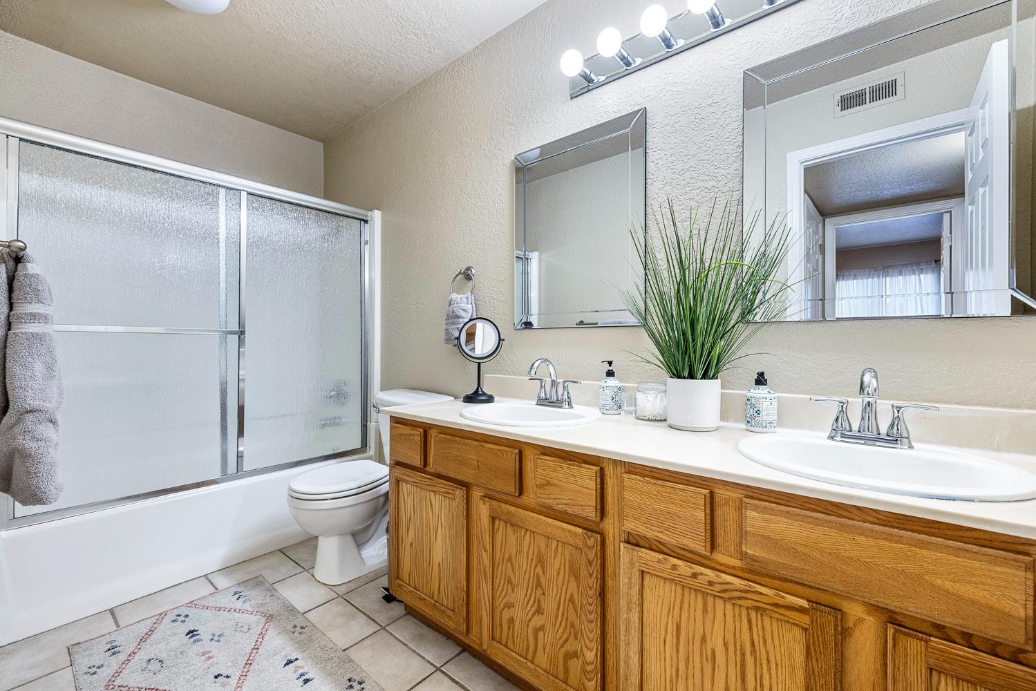 2881 Huntington Boulevard, Unit 137 Fresno, CA 93721 - Photo 18 of 29 a bathroom with a granite countertop sink toilet and mirror