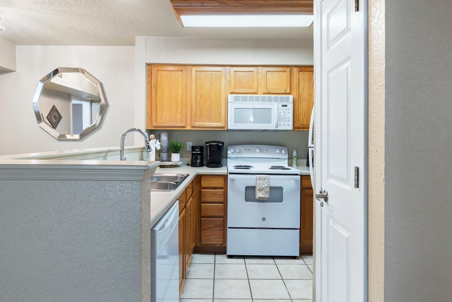 2881 Huntington Boulevard, Unit 137 Fresno, CA 93721 - Photo 6 of 29 a kitchen with a stove a sink and a window
