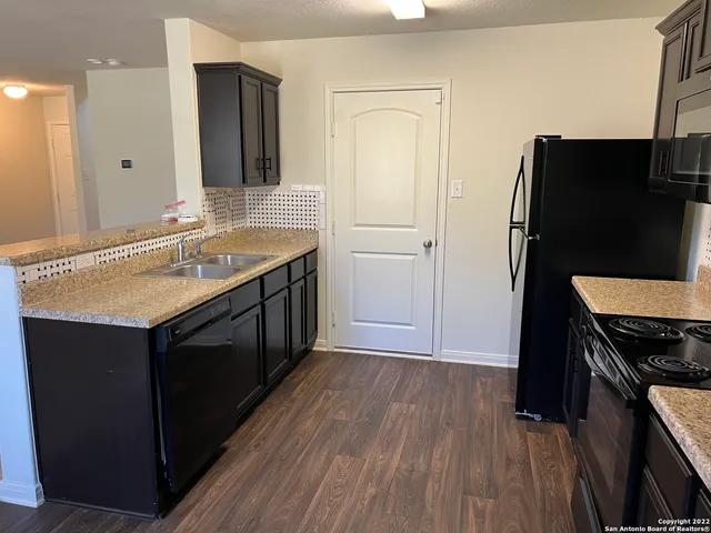 a kitchen with stainless steel appliances kitchen island granite countertop a refrigerator stove and sink