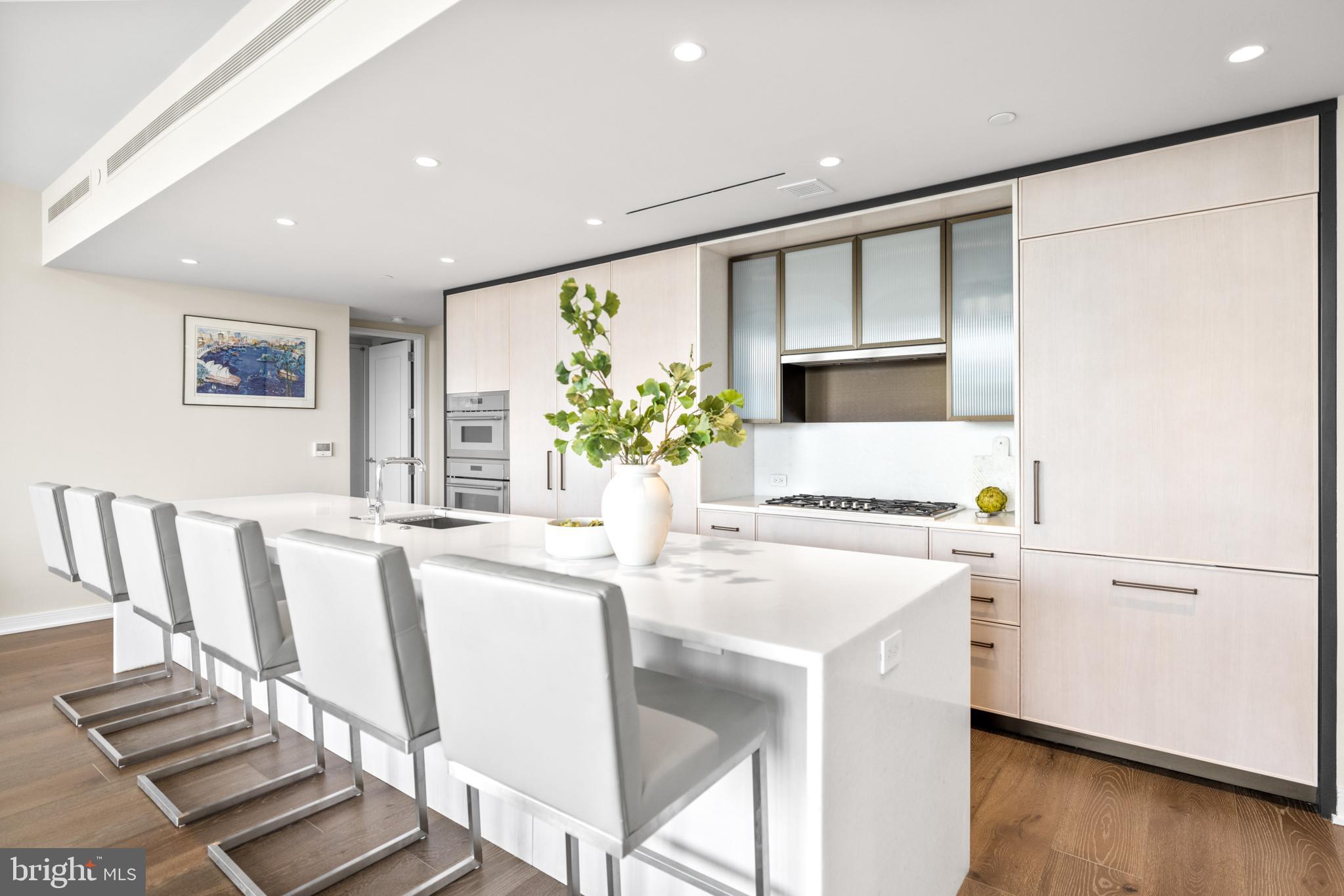 601 Wharf Street Southwest, Unit 602 Washington, DC 20024 - Photo 14 of 104 a kitchen with stainless steel appliances granite countertop a dining table chairs and a refrigerator