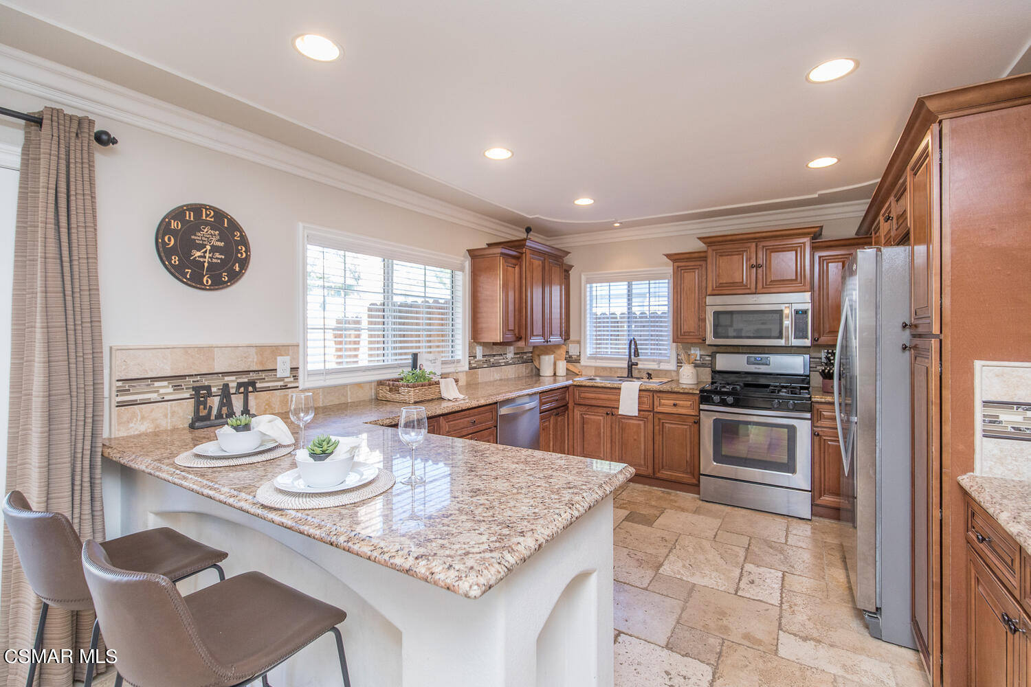 1871 Edgewood Drive Simi Valley, CA 93063 - Photo 9 of 26 a kitchen with stainless steel appliances granite countertop a stove top oven a sink a dining table and chairs