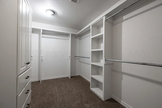 a view of a hallway with wooden cabinets and staircase