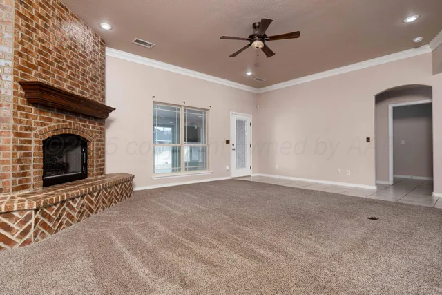 a view of an empty room with a fireplace and a window