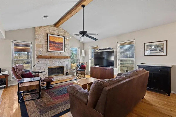 a living room with furniture a flat screen tv and a fireplace