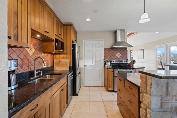 a kitchen with stainless steel appliances granite countertop a sink stove and refrigerator