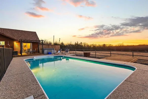 a view of swimming pool with outdoor seating and yard in back
