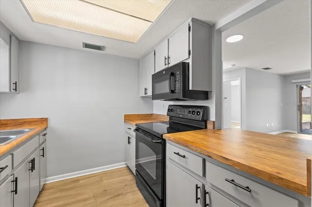 a kitchen with stainless steel appliances a stove microwave and refrigerator