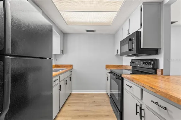 a kitchen with stainless steel appliances granite countertop a refrigerator a stove and a sink