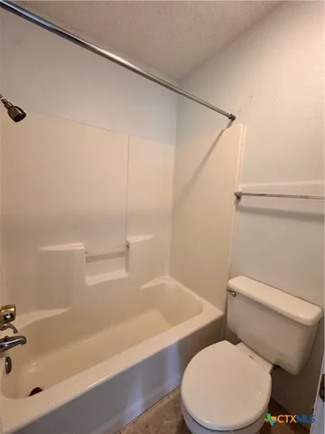 a white toilet sitting next to a bath tub and a shower