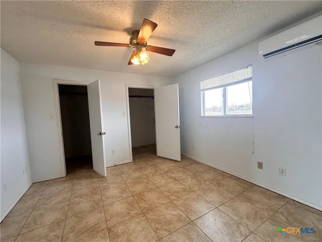 an empty room with closet and windows