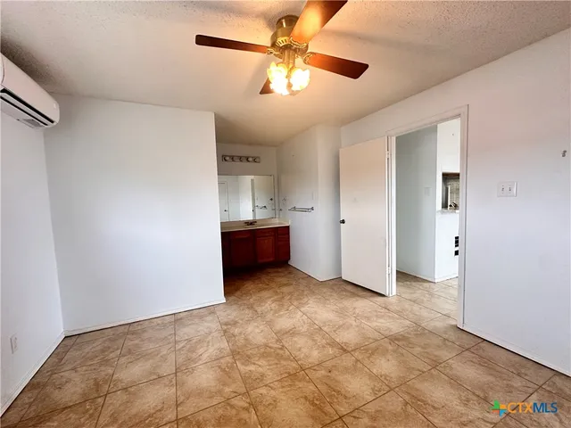 a view of an empty room with a ceiling fan