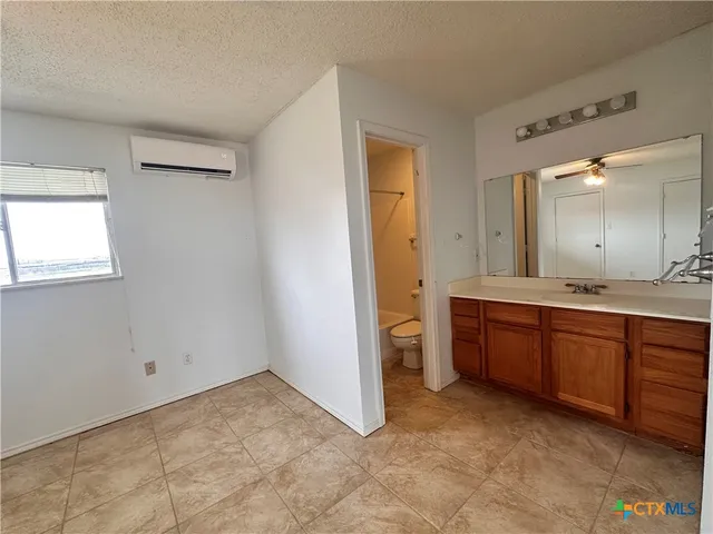 a spacious bathroom with a granite countertop sink and a mirror