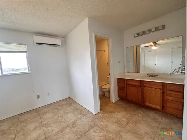 a spacious bathroom with a granite countertop sink and a mirror