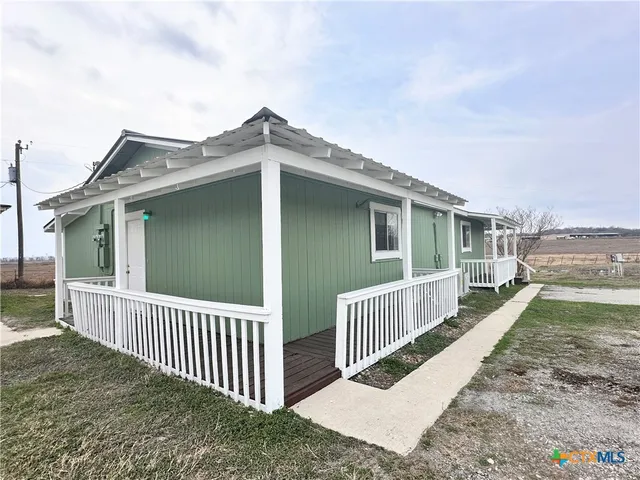 a view of a house with a small yard and wooden fence