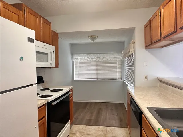 a kitchen with a cabinets and white appliances
