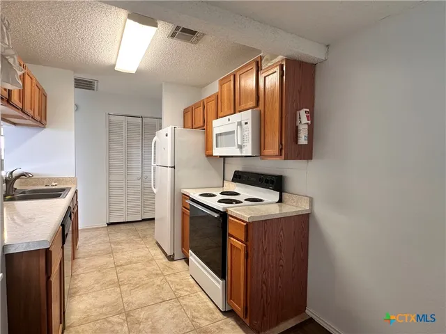 a kitchen with a stove top oven and refrigerator