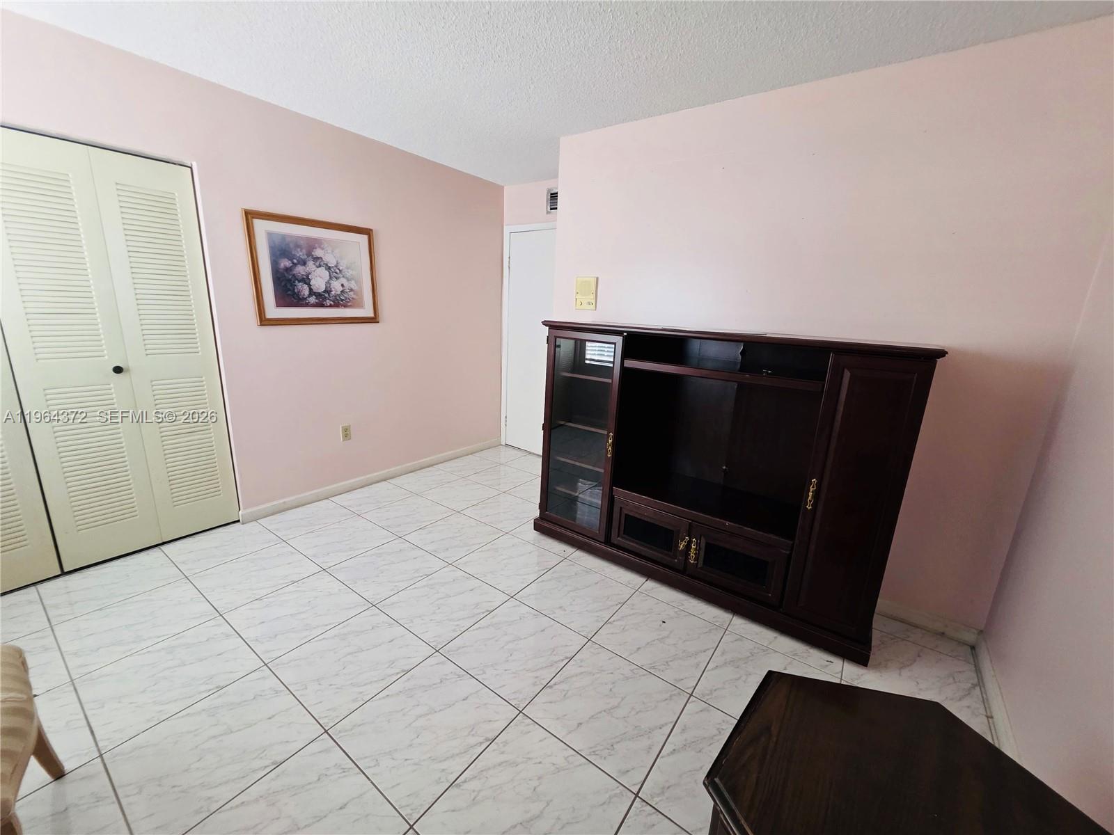 725 Northwest 123rd Avenue Miami, FL 33182 - Photo 11 of 18 a living room with a large mirror and a flat screen tv