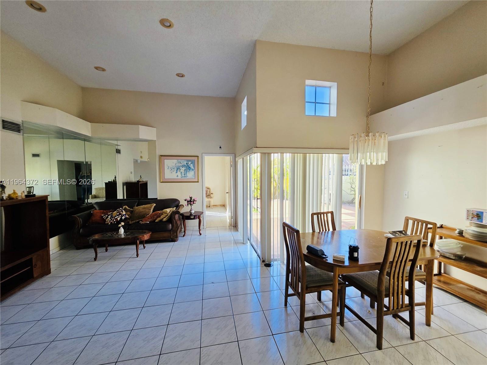 725 Northwest 123rd Avenue Miami, FL 33182 - Photo 4 of 18 a living room with furniture two large window and a dining table