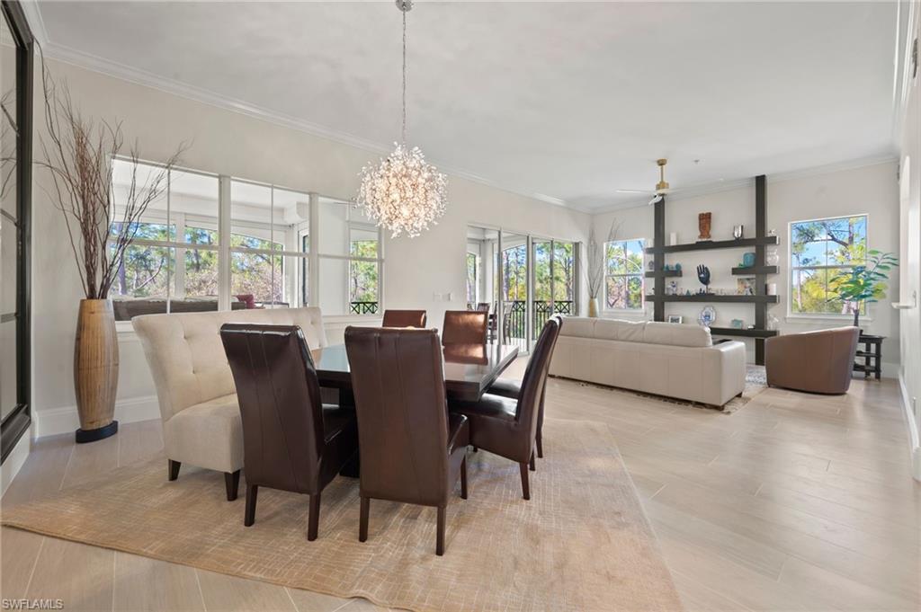 2886 Castillo Court, Unit 103 Naples, FL 34109 - Photo 13 of 38 a view of a dining room with furniture a chandelier and large windows