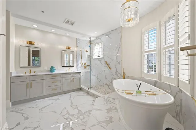 a bathroom with a granite countertop sink mirror and a bath tub