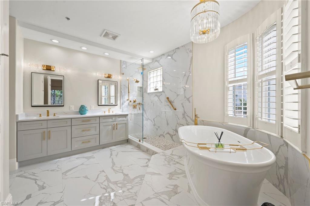 2886 Castillo Court, Unit 103 Naples, FL 34109 - Photo 22 of 38 a large spacious bathroom with a bathtub and a sink