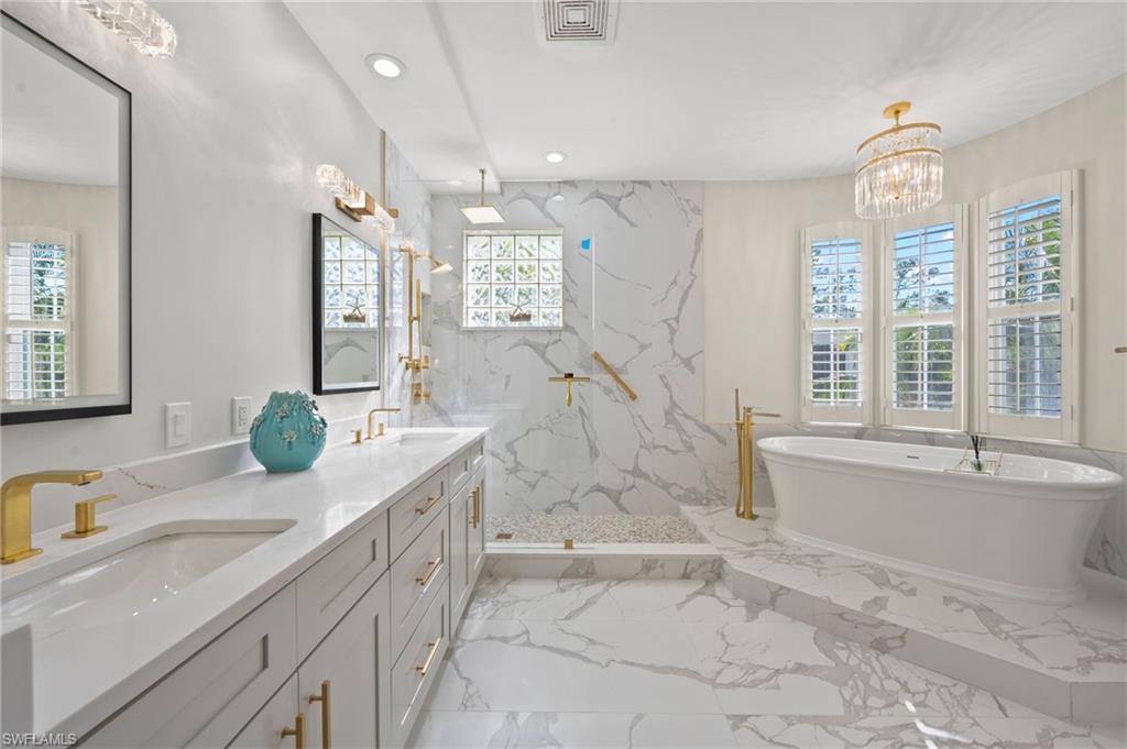 2886 Castillo Court, Unit 103 Naples, FL 34109 - Photo 23 of 38 a bathroom with a granite countertop sink mirror and a bath tub