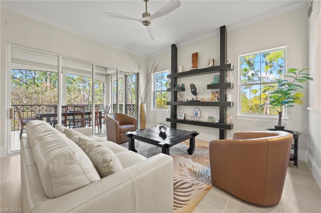 2886 Castillo Court, Unit 103 Naples, FL 34109 - Photo 5 of 38 a living room with furniture and large windows