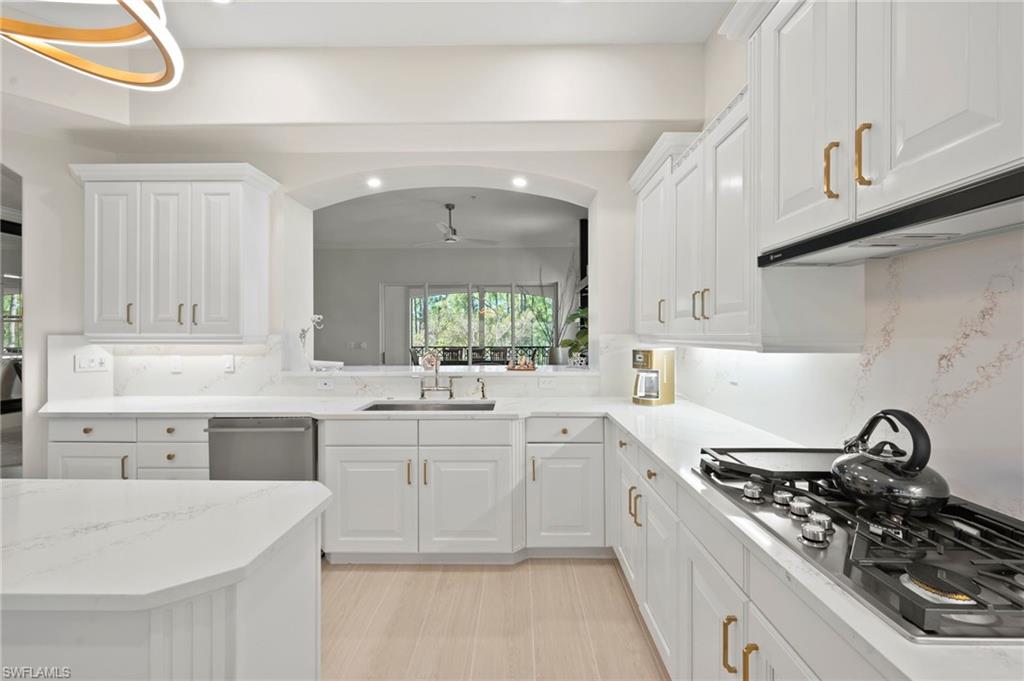 2886 Castillo Court, Unit 103 Naples, FL 34109 - Photo 5 of 38 a kitchen with white cabinets and appliances