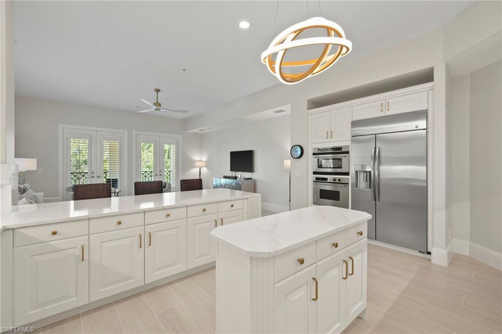 2886 Castillo Court, Unit 103 Naples, FL 34109 - Photo 6 of 38 a kitchen with cabinets and stainless steel appliances