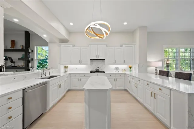 a large kitchen with stainless steel appliances lots of counter space and a sink