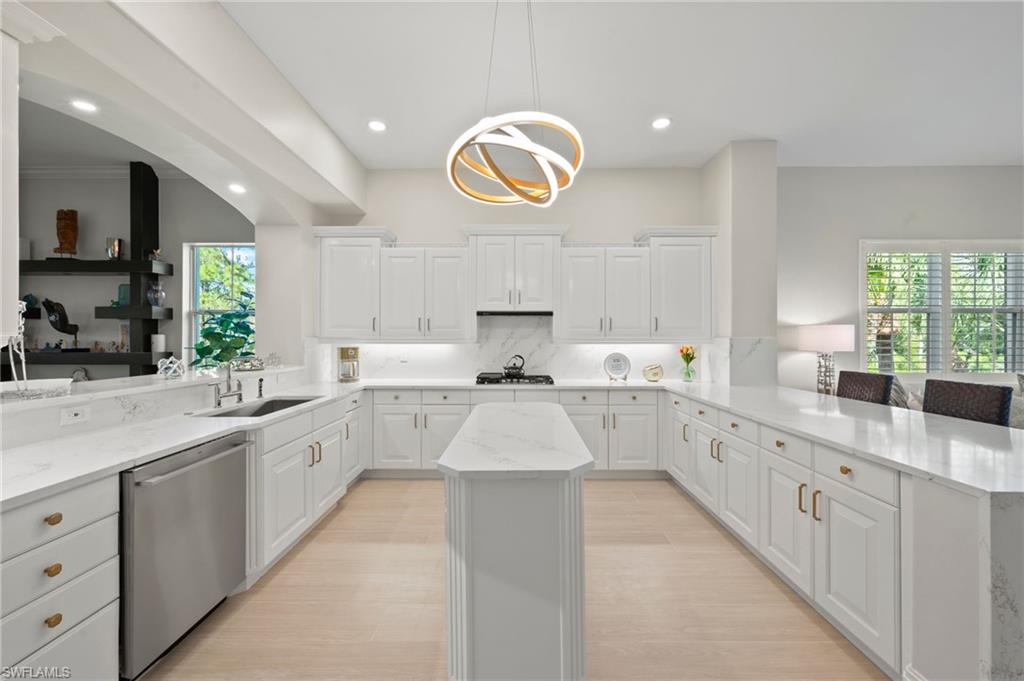 2886 Castillo Court, Unit 103 Naples, FL 34109 - Photo 6 of 38 a large kitchen with stainless steel appliances lots of counter space and a sink