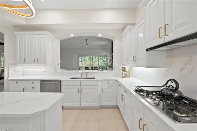 a kitchen with white cabinets and appliances