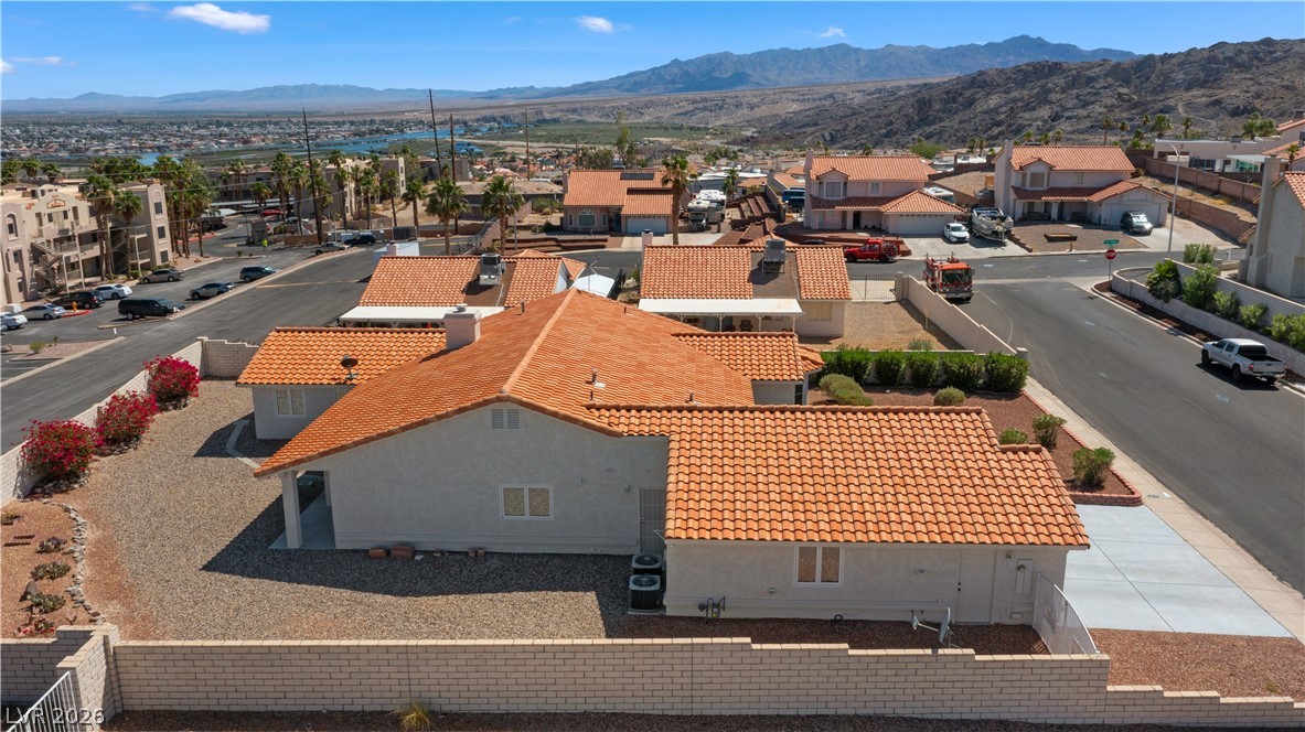2055 Cholla Way Laughlin, NV 89029 - Photo 72 of 87 An aerial perspective reveals the property's terracotta roof and desert landscaping, set against a distant cityscape and mountains.